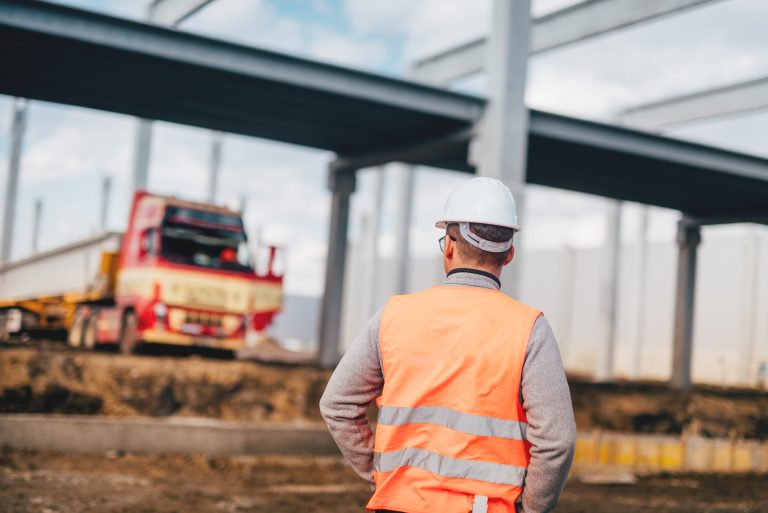 engineer working on construction site, working with machinery and excavators, managing building site
